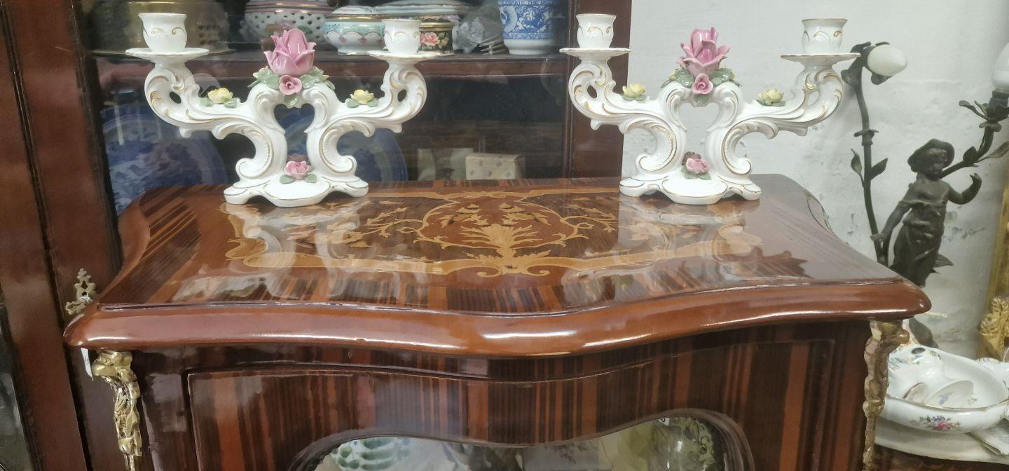 An elegant inlaid showcase having upholstered back,glass shelves brass